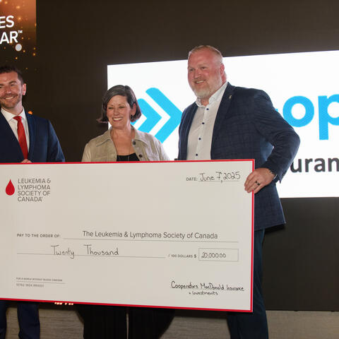 Dan MacDonald Cooperators MacDonald Insurance, presents a CQ on stage for $20,000 to LLSC staff Daniel Blacquiere and Nancy MacDonald.