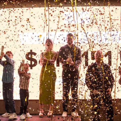 2025 Halifax Candidate Class celebrate on stage the Grand Total announcement of $413,151 raised, at Steele Wheels Auto Museum in Halifax.