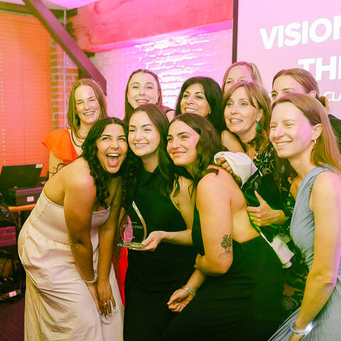 Participants gather together for a celebratory photo as one guest holds an award during the gala evening.