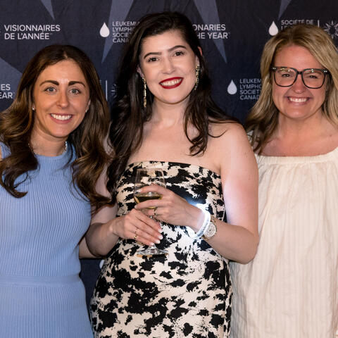 Three Committee members pose together in front of the Visionaries of the Year backdrop during the reception.