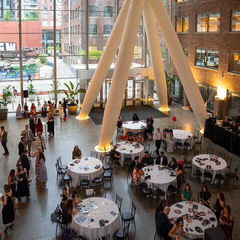 Participants and attendees engage during a fundraising event, connecting and celebrating together in the event space.